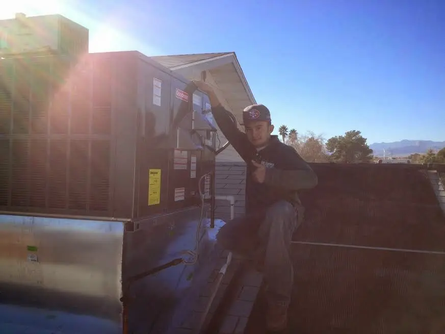 HVAC technician performing HVAC Inspection on a rooftop unit in Kingstowne